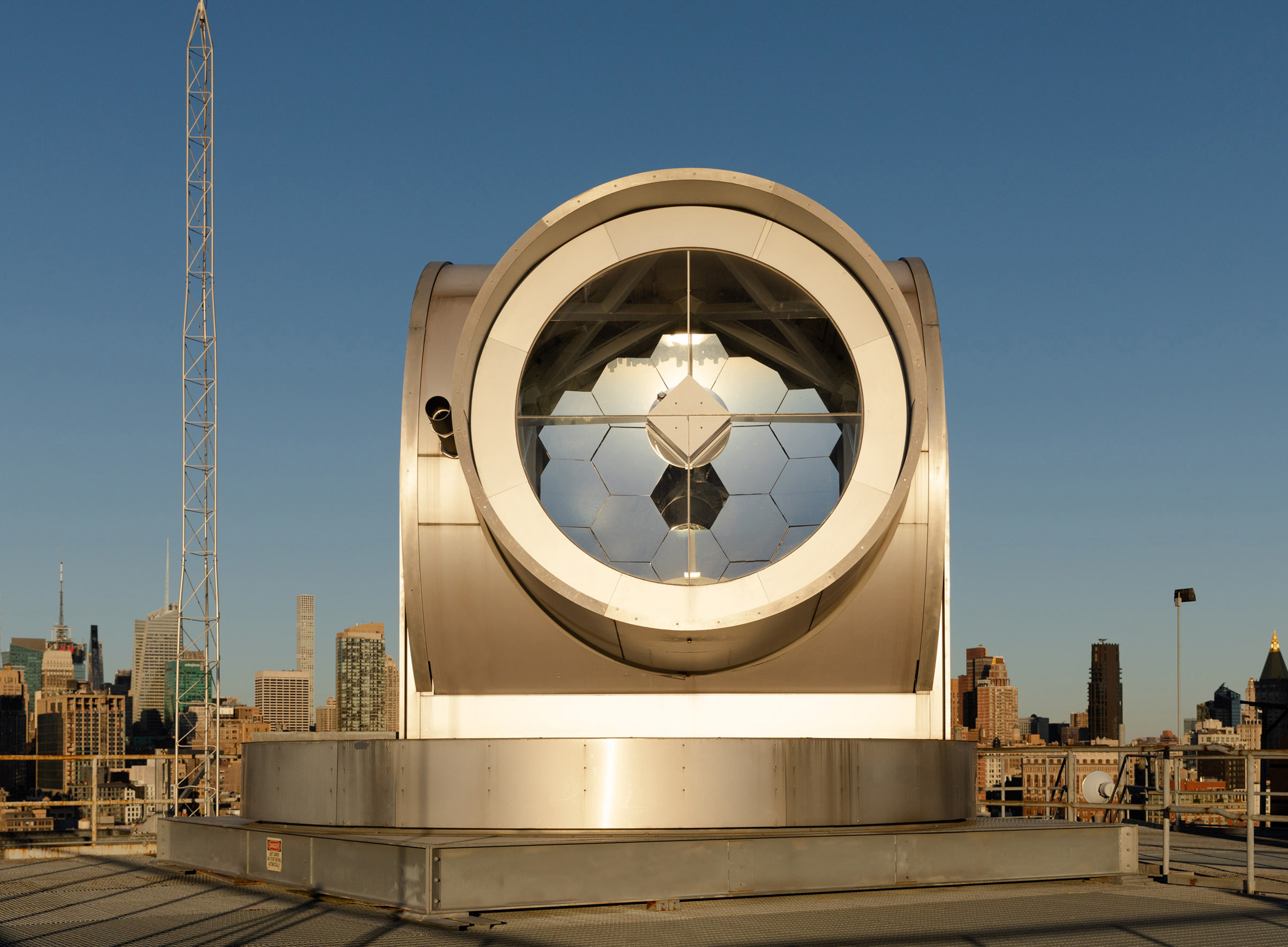 a solar telescope sitting on top of a high rise in manhattan