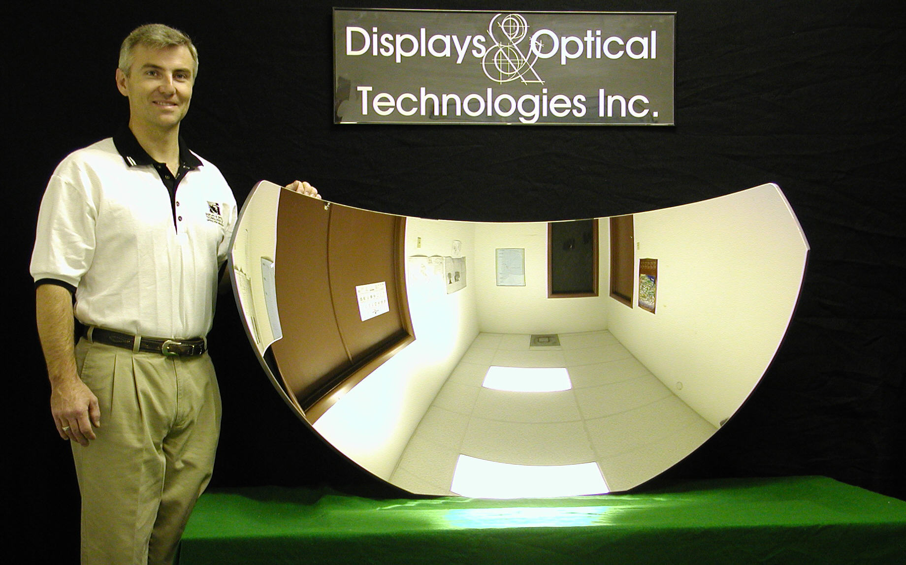 man standing next to spherical curved mirror